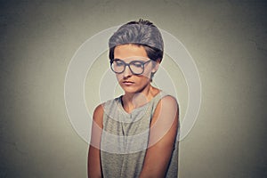 Lack of confidence. Shy young woman in glasses feels awkward