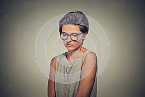 Lack of confidence. Shy young woman in glasses feels awkward photo