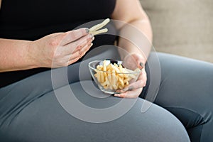Fat woman overeating junk food. sedentariness