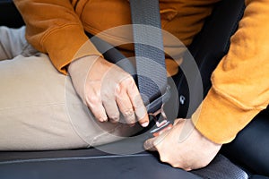 Lack a seat belt before driving a car, Closeup of man fastening seat belt in car, Safety belt safety first.
