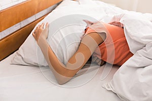 Lack of sleep. Woman covering head with pillow photo