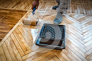 Lacquering wood floors. Use roller for coating floors