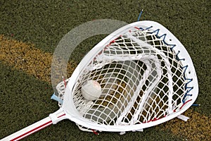 Lacrosse goalie stick with ball in the net