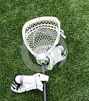 Lacrosse goalie stick with hgloves on turf field
