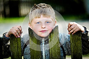 A lad of the village behind the fence photo