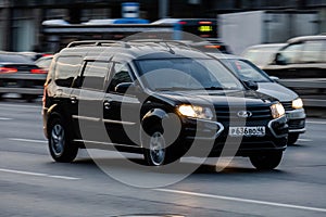 lada largus car moving on the street. Estate vehicle driving along highway in city with blurred background