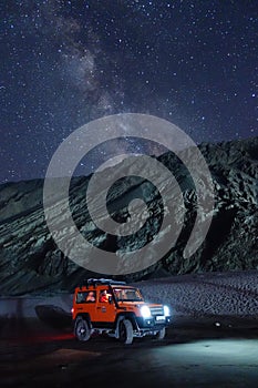 Ladakh, India - August 24th, 2022: Extreme long exposure image showing Milkyway Galaxy over an SUV offroad vehicle in the