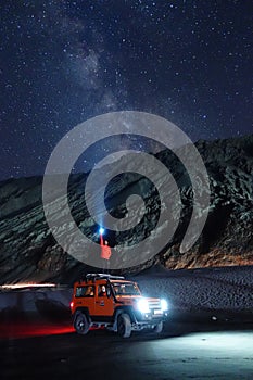 Ladakh, India - August 24th, 2022: Extreme long exposure image showing Milkyway Galaxy over an SUV offroad vehicle in the