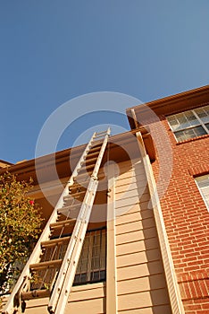 Ladder leaning on tall building