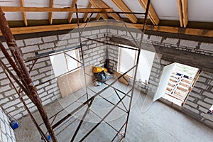 Ladder, parts of scaffolding and construction material on the floor during on the remodeling, renovation, extension, restoration,