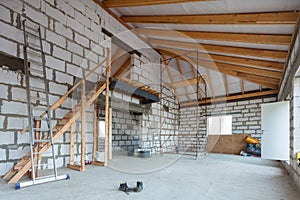 Ladder, parts of scaffolding and construction material on the floor during on the remodeling, renovation, extension, restoration