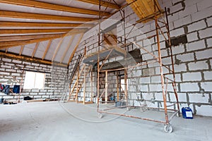 Ladder, parts of scaffolding and construction material on the floor during on the remodeling, renovation, extension, restoration