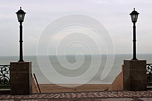 Ladder with street lamps on the descent to the sea in the offseason