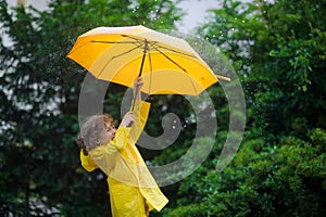 Laddie with a bright yellow umbrella in the rain.