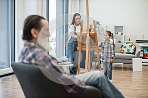 Ladies drawing image of grandad on canvas in art classroom