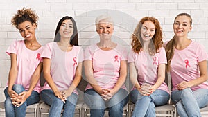 Ladies In Pink T-Shirts Sitting On Chairs Smiling Indoor, Panorama