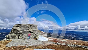 Ladinger Spitz - Woman with backpack resting next to massive rock formation at Steinerne Hochzeit, Saualpe, Lavanttal Alps, photo