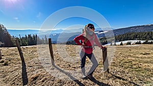 Ladinger Spitz - Woman on hiking trail standing next to fence on alpine meadow near Ladinger Spitz, Saualpe, Lavanttal Alps