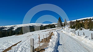 Ladinger Spitze - Snow covered hiking trail along alpine fence on the way to mountain peak Ladinger Spitz, Saualpe,