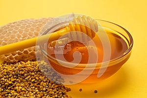 A ladle of honey on the background of a honeycomb of a bee. Honey tidbit in a glass jar honey spoon, bee bread and a