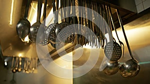 Ladles And Skimmers Hanging On The Hood Of A Restaurant Kitchen