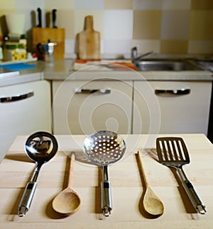Ladles on wooden table on kitchen background