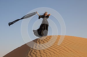 Lady in abaya in sand dunes photo