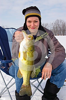 Lady Angler Fisherwoman Holds a Large Mouth Bass Caught Ice Fishing photo