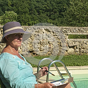 A lady artist sits working on a painting