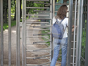 Lady with a backpack turnstiles in a private Park.