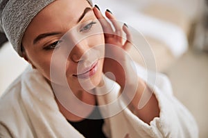 Lady with a bathtowel wrapped around her head staring away