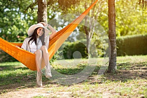 Lady with big hat sitting in hammock