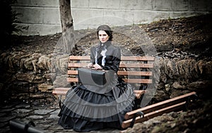 Lady in black sitting on a bench