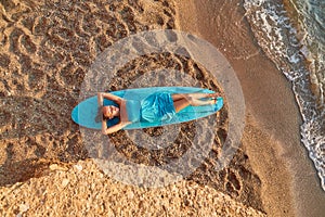 Lady in blue dress warm up on sun. Girl relax on sandy beach. Desire of adventure, summer time and holiday trip idea
