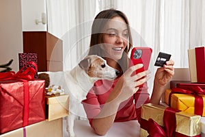 Lady buying online with credit card and smartphone home pet