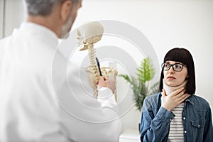 Lady in C collar visiting doctor in clinic for consultation