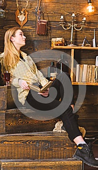 Lady on calm face in plaid clothes looks casual. Relaxation concept. Girl student relaxing with book and glass of mulled