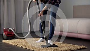 Lady carefully vacuuming bed mat, bringing house to order, allergy prevention