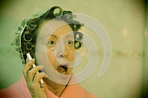 Lady with curlers surprised on the phone
