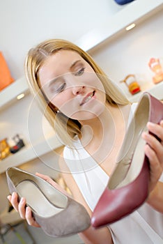 Lady deliberating between two shoes