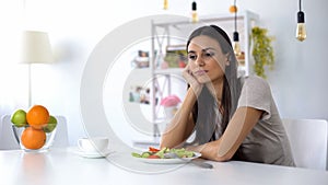 Lady dissatisfied with salad, dreaming about junk food, healthy low-calorie diet