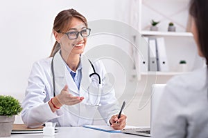 Lady Doctor Talking With Unrecognizable Patient During Appointment In Office photo