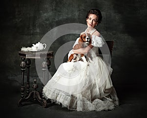 Lady with dog. Vintage portrait of young elegant woman in image of medieval person in renaissance style dress 