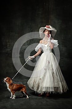 Lady with dog. Vintage portrait of young elegant woman in image of medieval person in renaissance style dress isolated