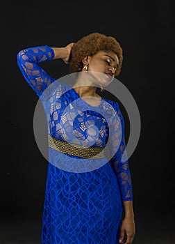 Lady in dress made out of lace. African females beauty concept. Woman with african appearance in blue dress looks