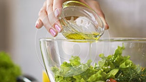 Lady dressing fresh summer salad with olive oil, diet food, slow motion