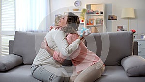 Lady embracing mother, senior woman holding gift box, pleasant surprise, care