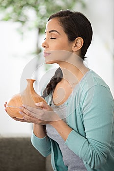 Lady enjoying scent from essential oils diffuser
