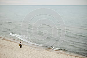 Lady enjoying sea noise while strolling along shore