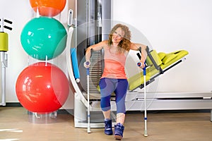 Lady at exercise machine with crutches